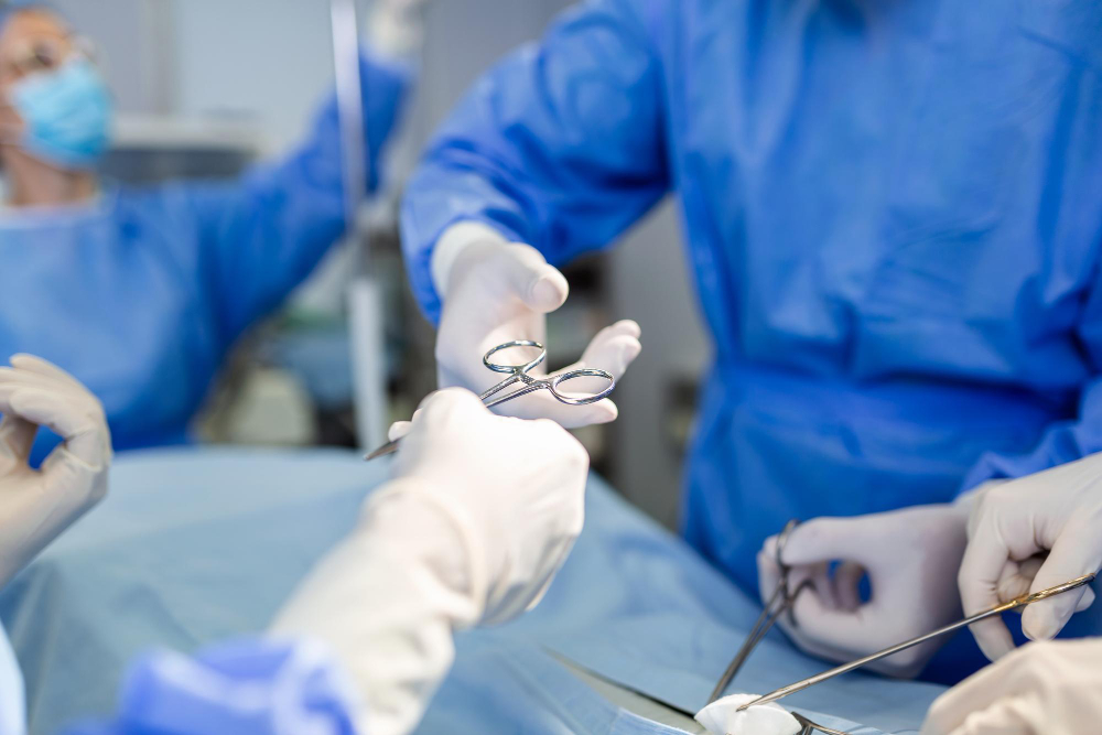 doctor nurse medical team are performing surgical operation emergency room hospital assistant hands out scissor instruments surgeons during operation