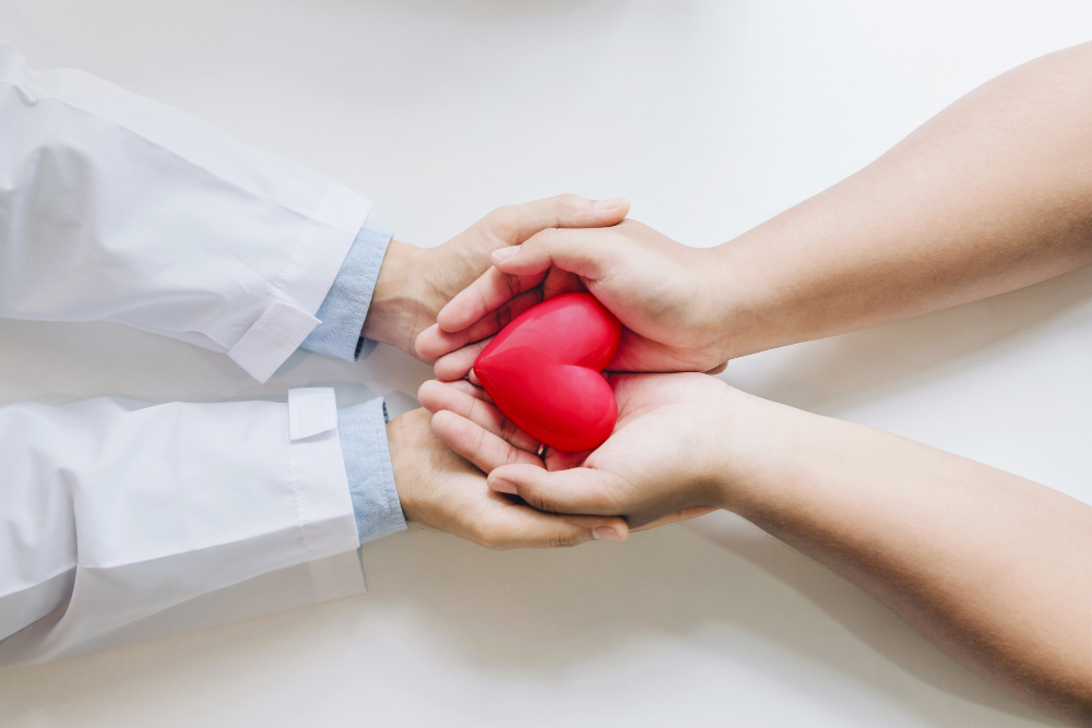 doctor patient holding red heart together