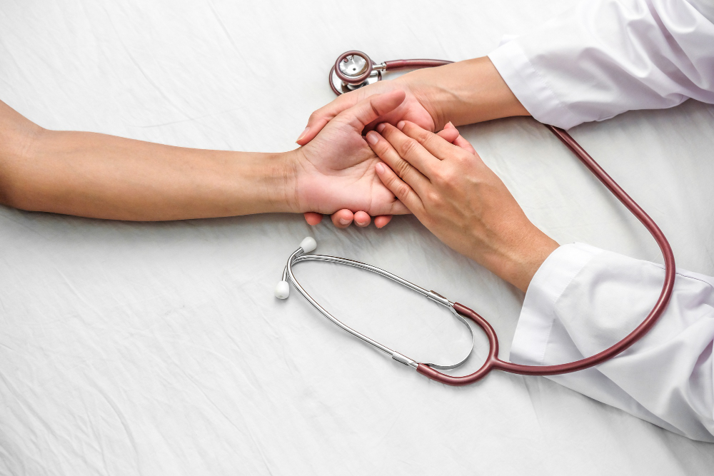 hand doctor reassuring her female patient