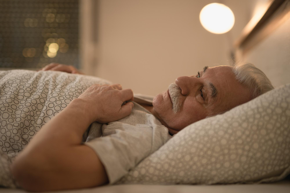 distraught senior man thinking something while lying down bed night