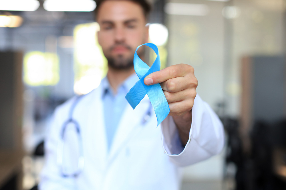 doctor hand with blue prostate cancer awareness ribbon medicine oncology closeup sky symbol