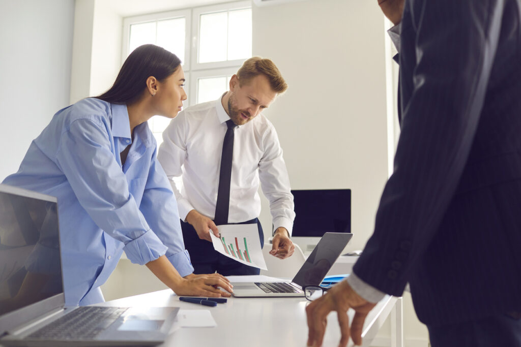 Professional male manager shows infographics to his colleagues during a meeting in the office