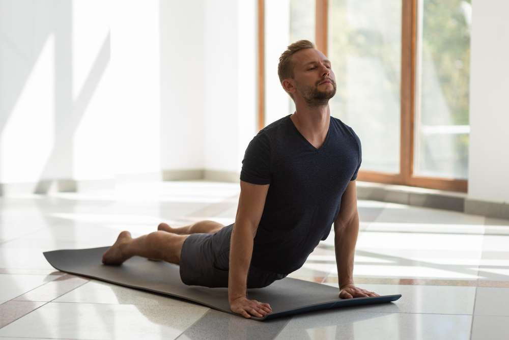 man doing cobra pose indoor