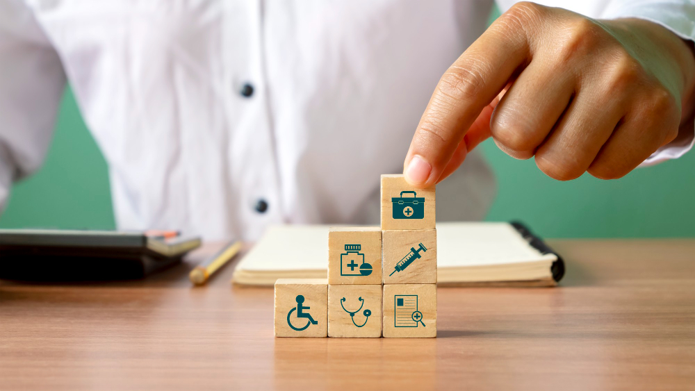 closeup human hand stacking wooden blocks overlapping health care icons medical icons