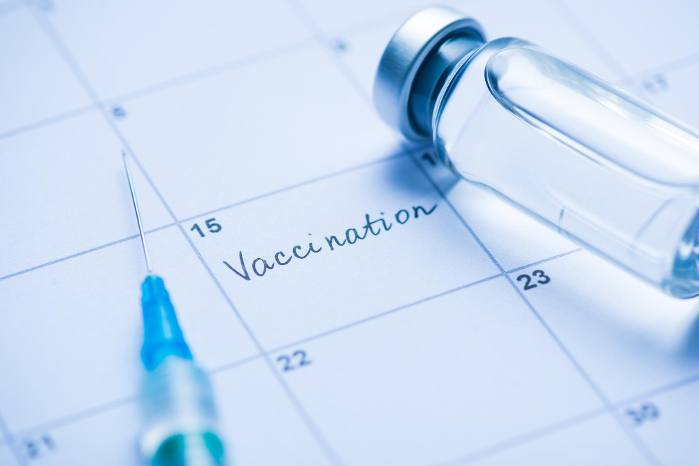 vaccination concept close up view photo vial with drugs needle syringe word vaccination written calendar cell