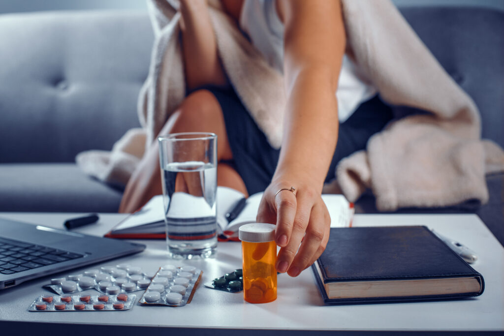 woman s hand with ring index finger reaches pills container